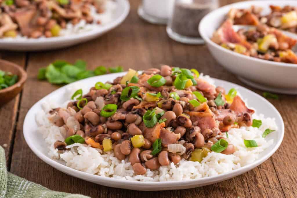 &frac34; angle view of hoppin John over white rice.