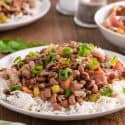 ¾ angle view of hoppin John over white rice.
