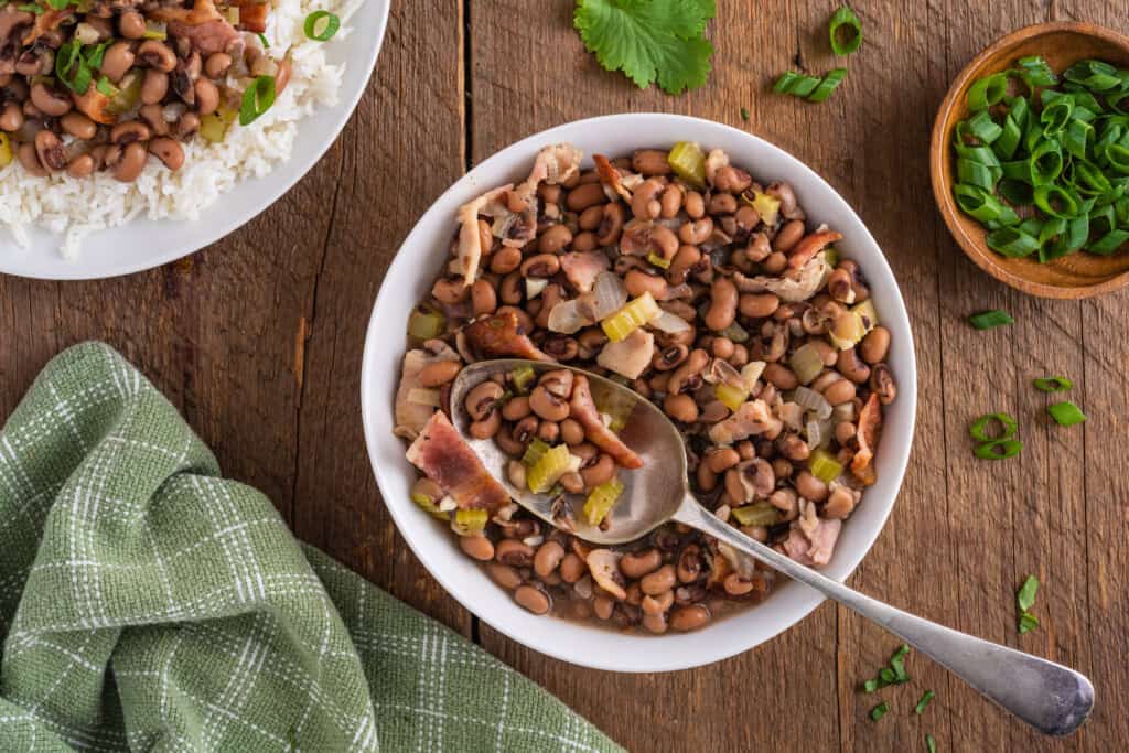 Overhead view of black eyed peas in a white bowl with a spoon