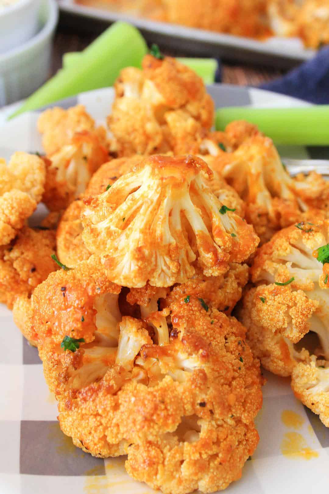 Close-up of Roasted Buffalo Cauliflower on checkered plate with celery