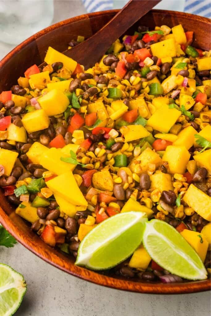 Mango black bean corn salad in large wooden bowl