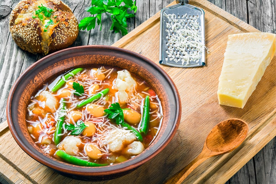 Minestrone vegetable soup with beans cauliflower tomatoes, close-up, top view