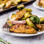 potatoes and sprouts and shallots on a white plate with a fork.