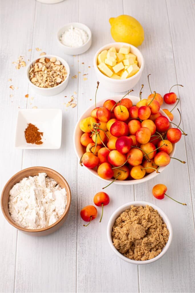 Ingredients for Rainier cherry crumble including fresh cherries, flour, brown sugar, almonds, butter, and lemon