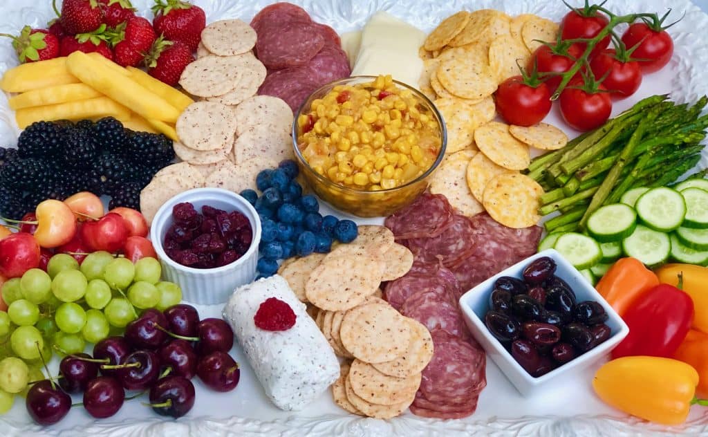 Create the perfect summer charcuterie platter: vegetables, fresh fruit, dried fruit, cheeses, cured meats, olives, salsa