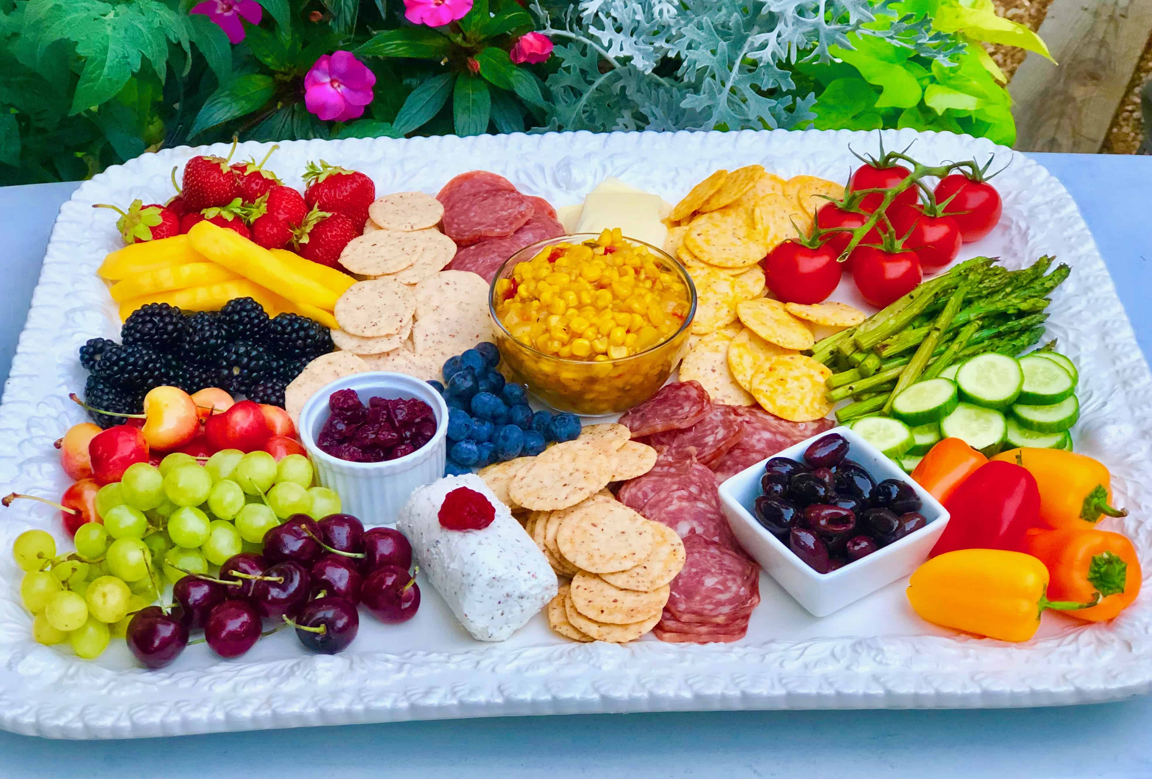 Create the perfect summer charcuterie platter: vegetables, fresh fruit, dried fruit, cheeses, cured meats, olives, salsa