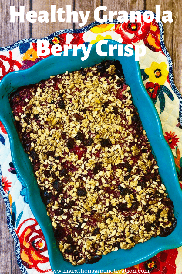 Granola berry crisp in a casserole dish on a colorful flower placemat.