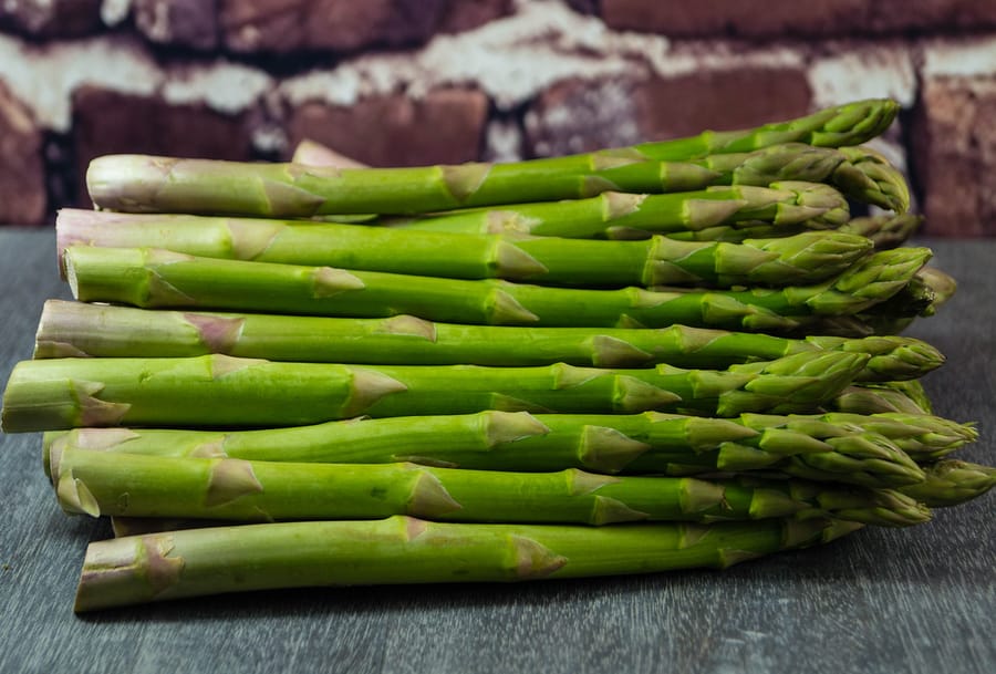 uncooked Fresh green german asparagus on a wooden table