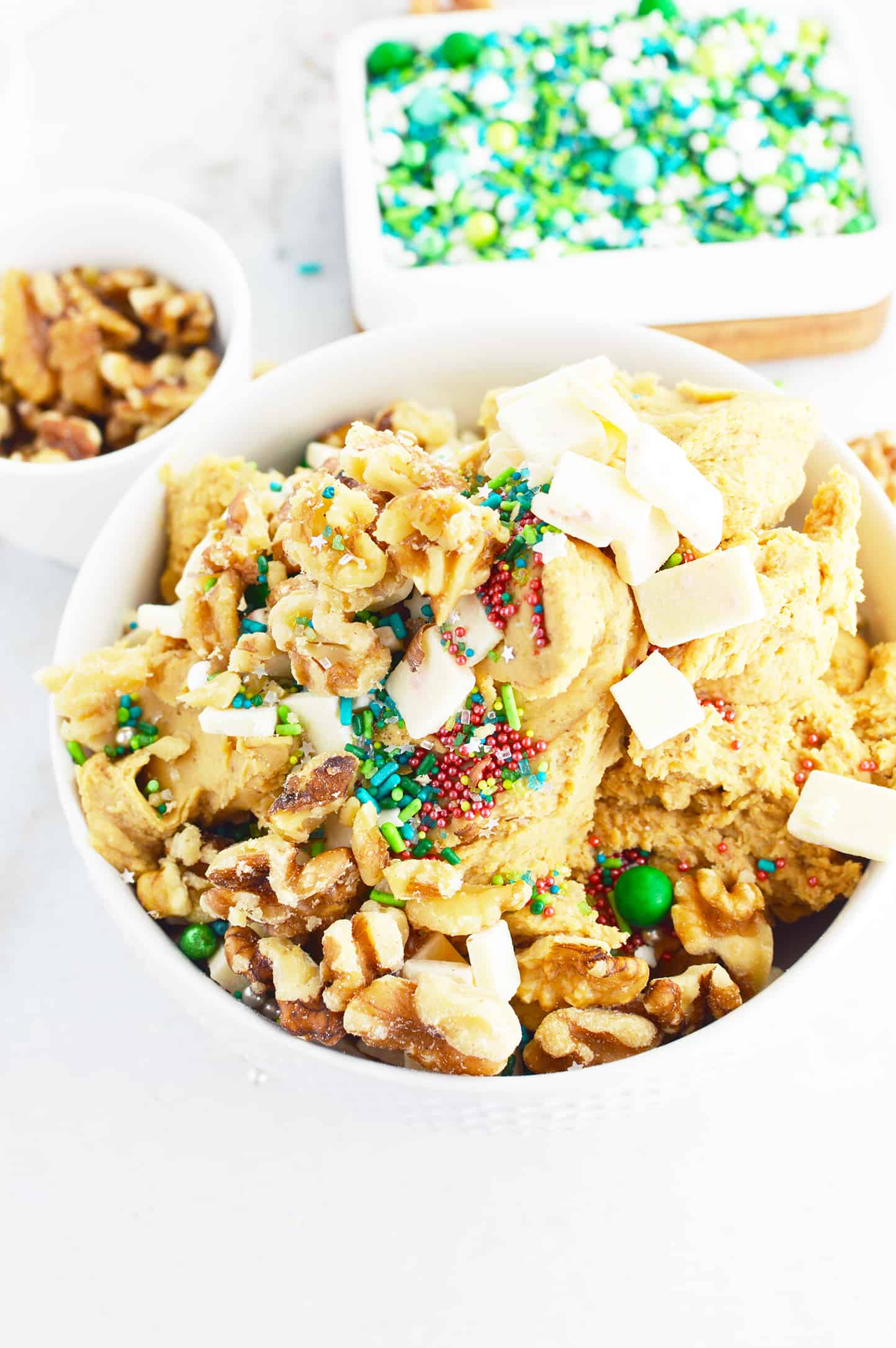 Healthy Edible Cookie Dough with holiday sprinkles and walnuts in the background.
