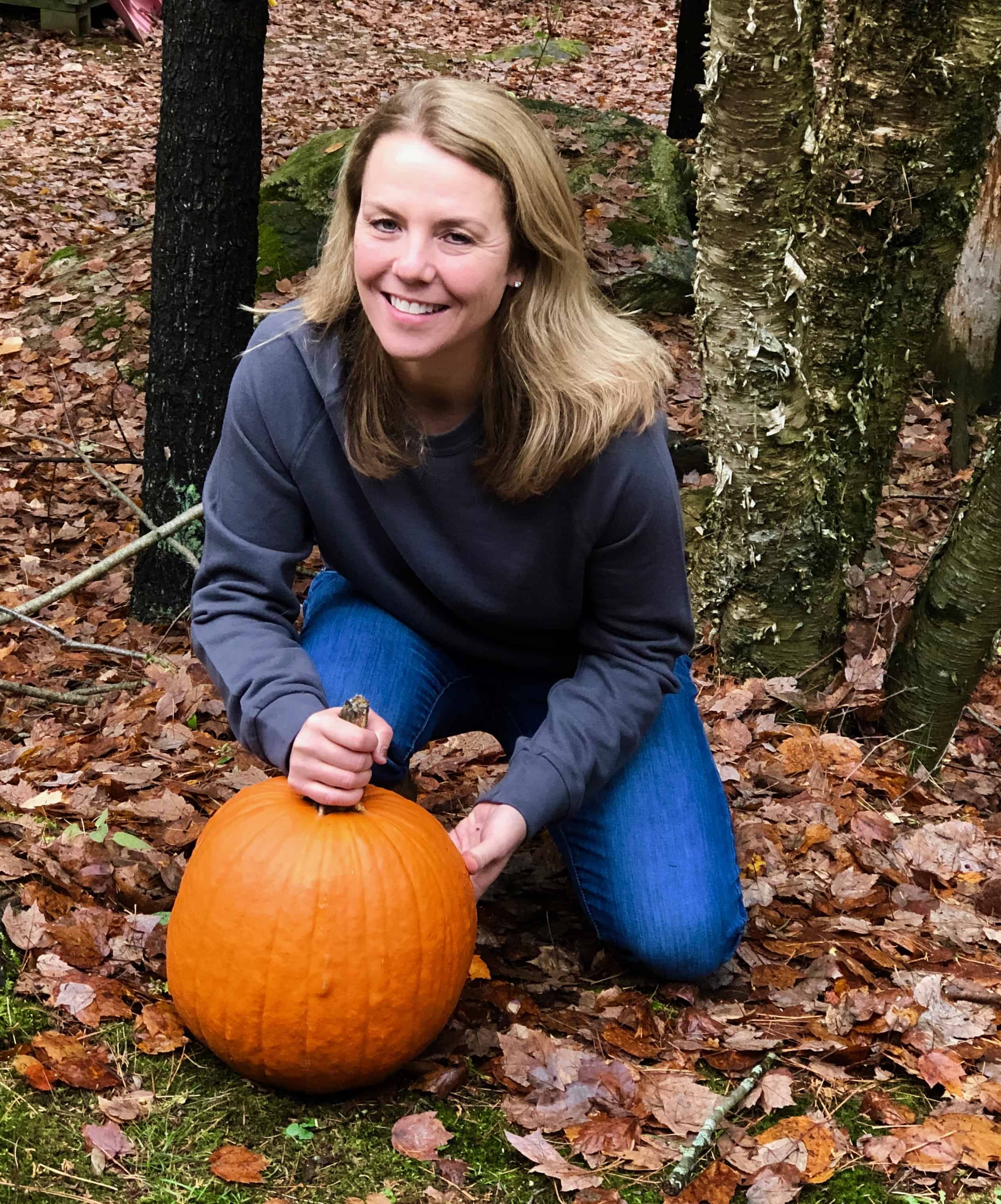 beautiful blonde woman in Gray sweatshirt with pumpkin