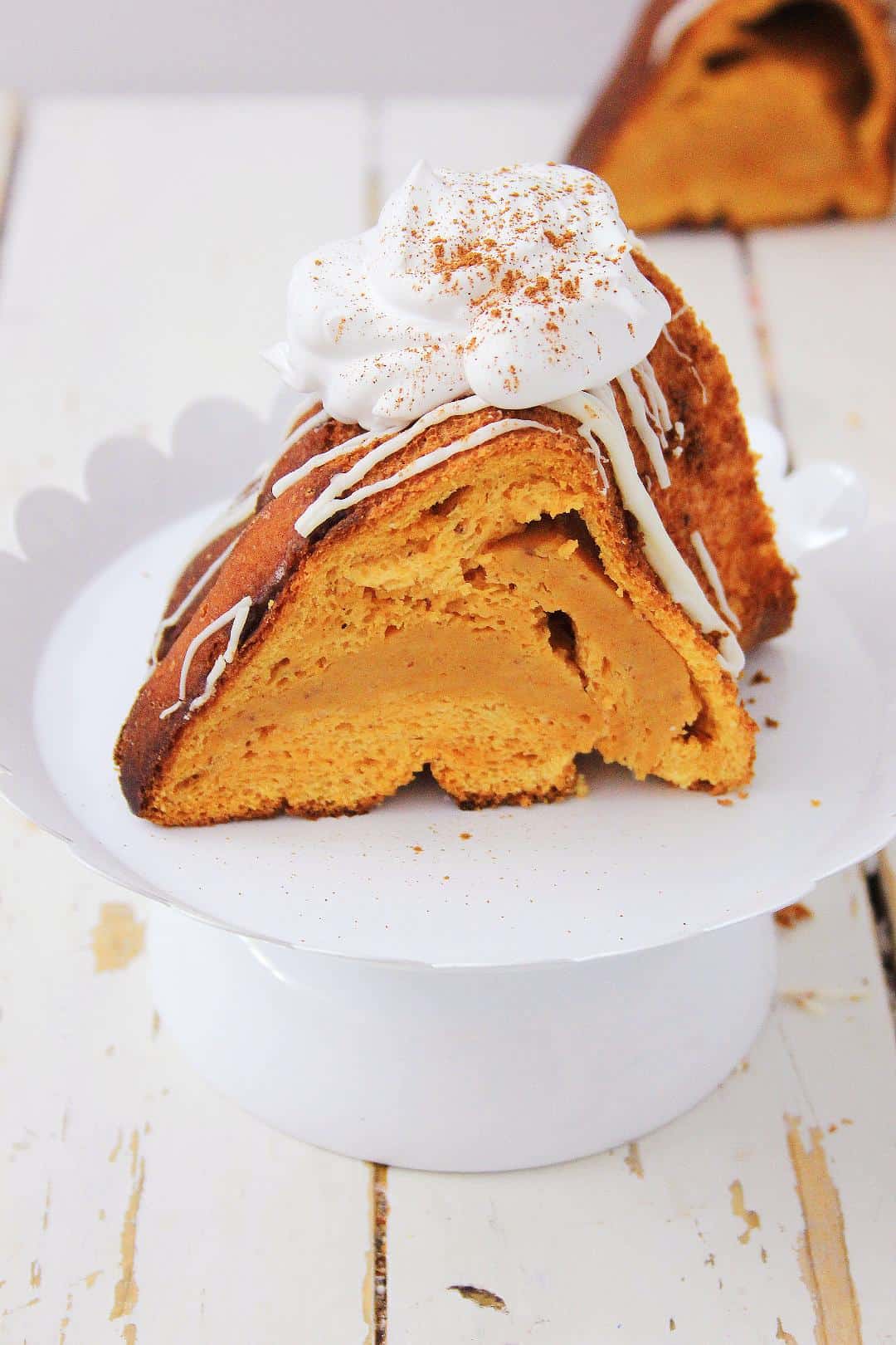 Pumpkin Angel Food Cake on a white cake stand with a white background.
