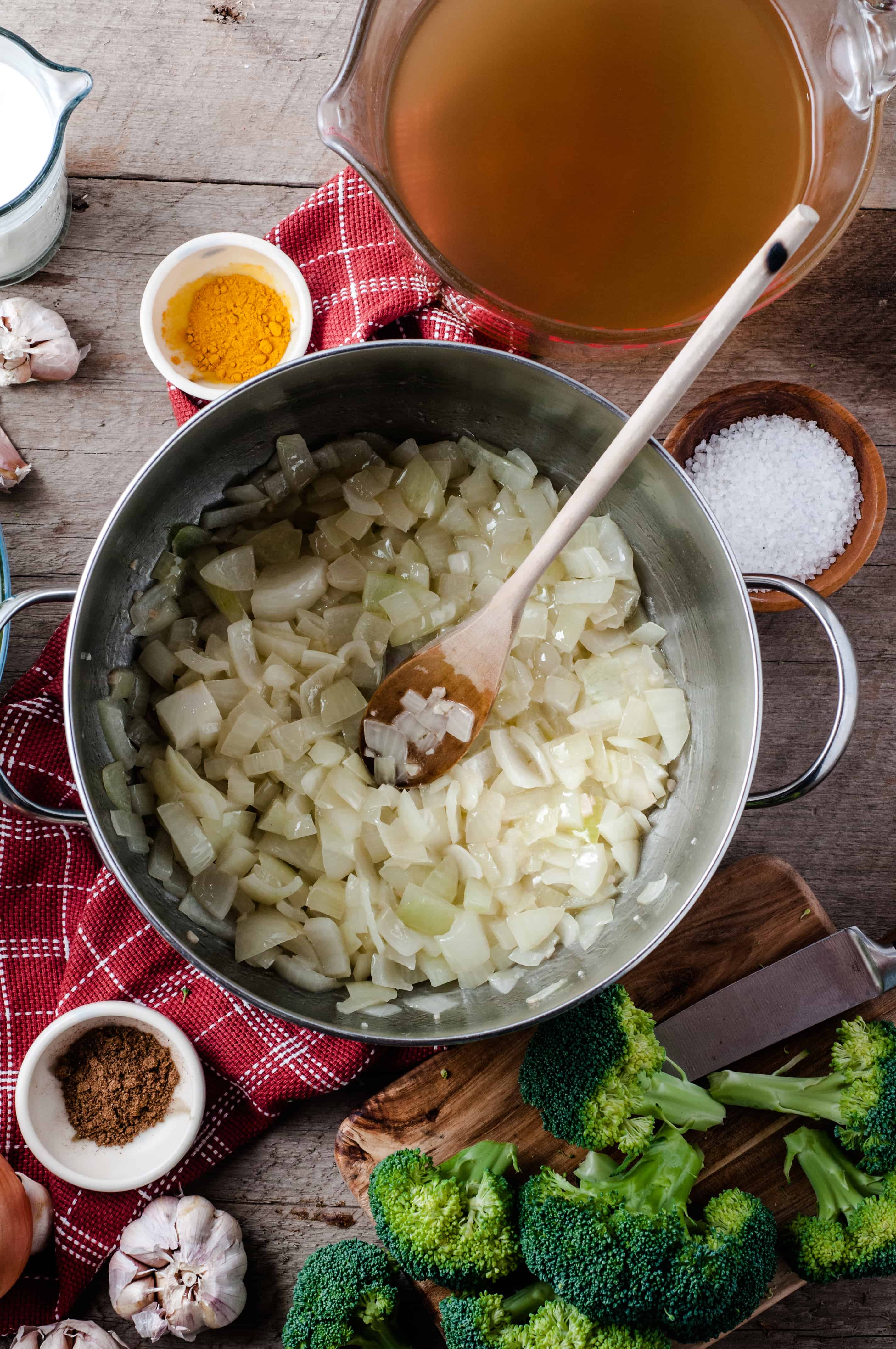 onions sauteed in pan with cream of broccoli soup ingredients around it