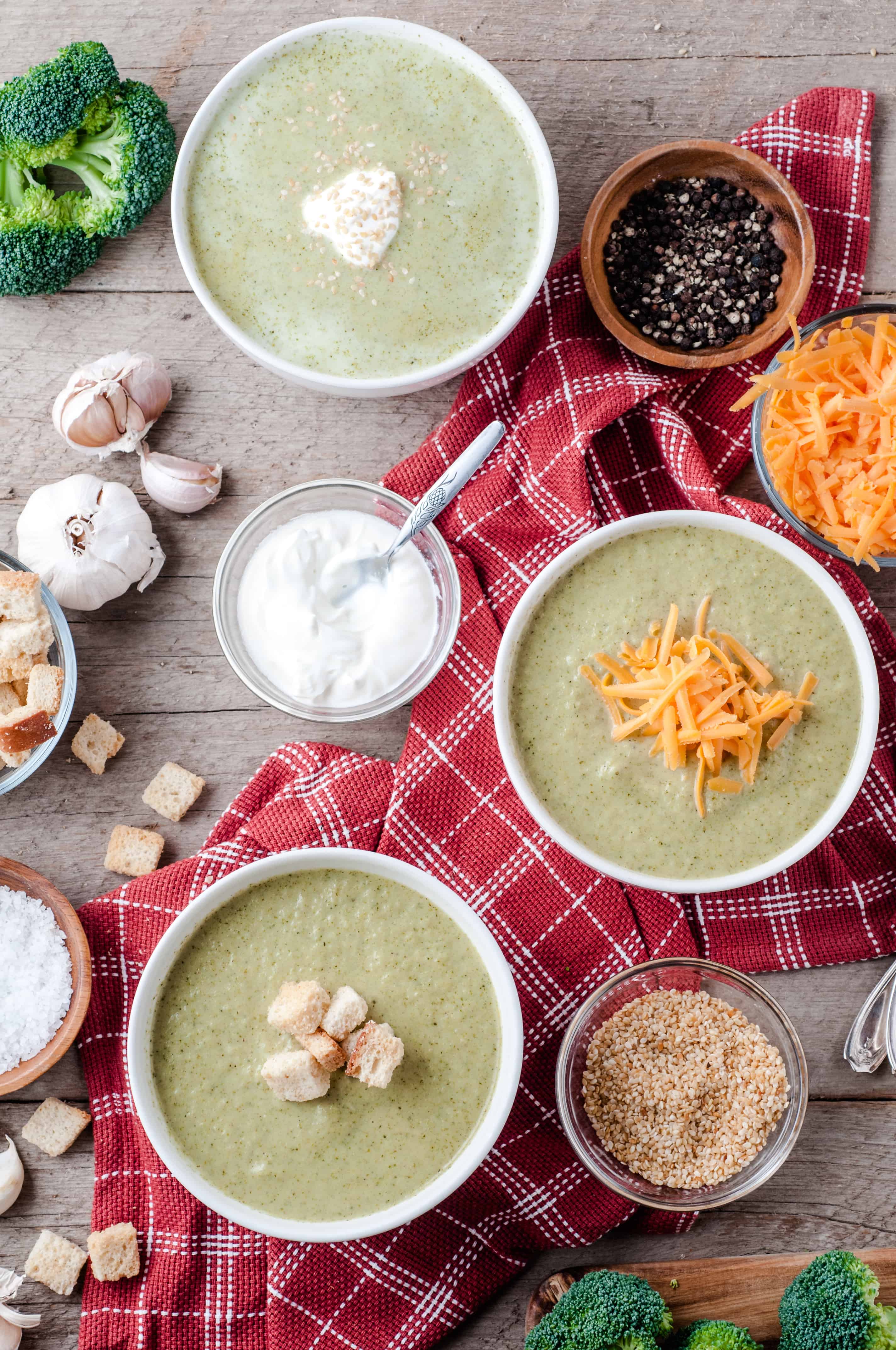3 bowls of Vegetarian Cream of Broccoli soup with toppings.
