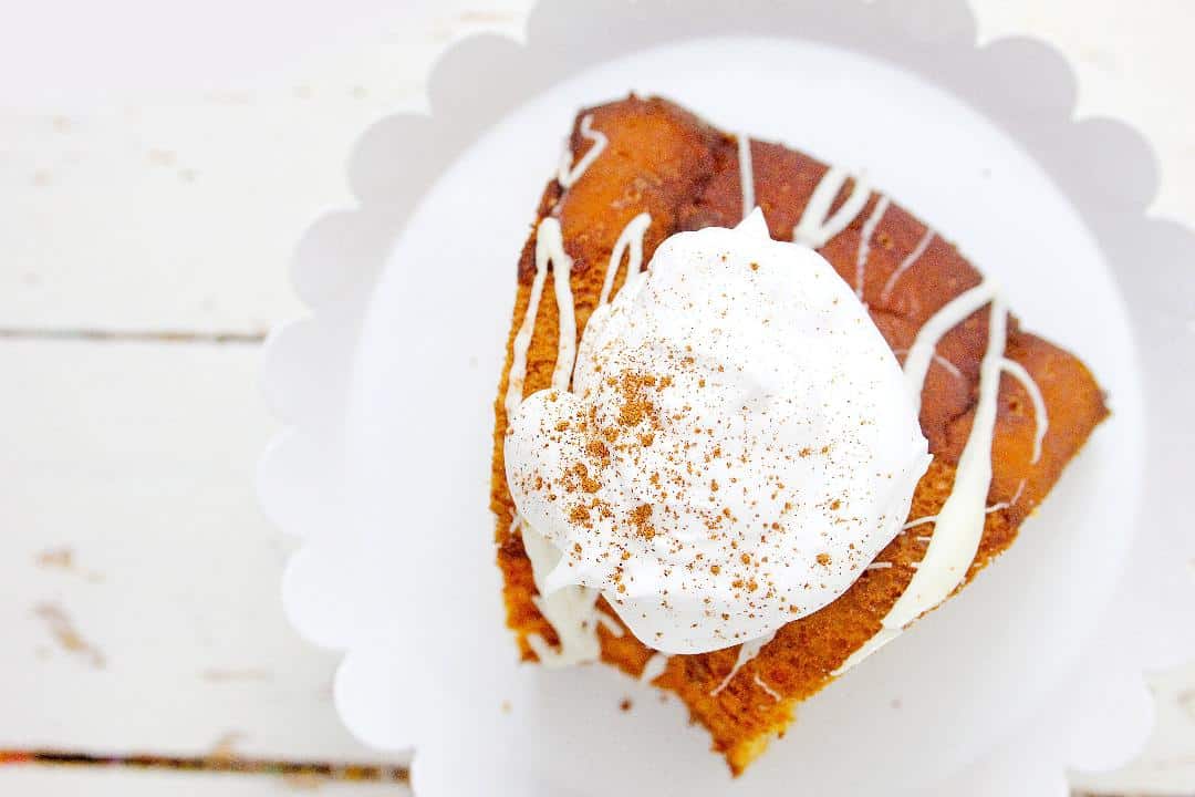Pumpkin Angel Food Cake on a white cake stand with a white background.