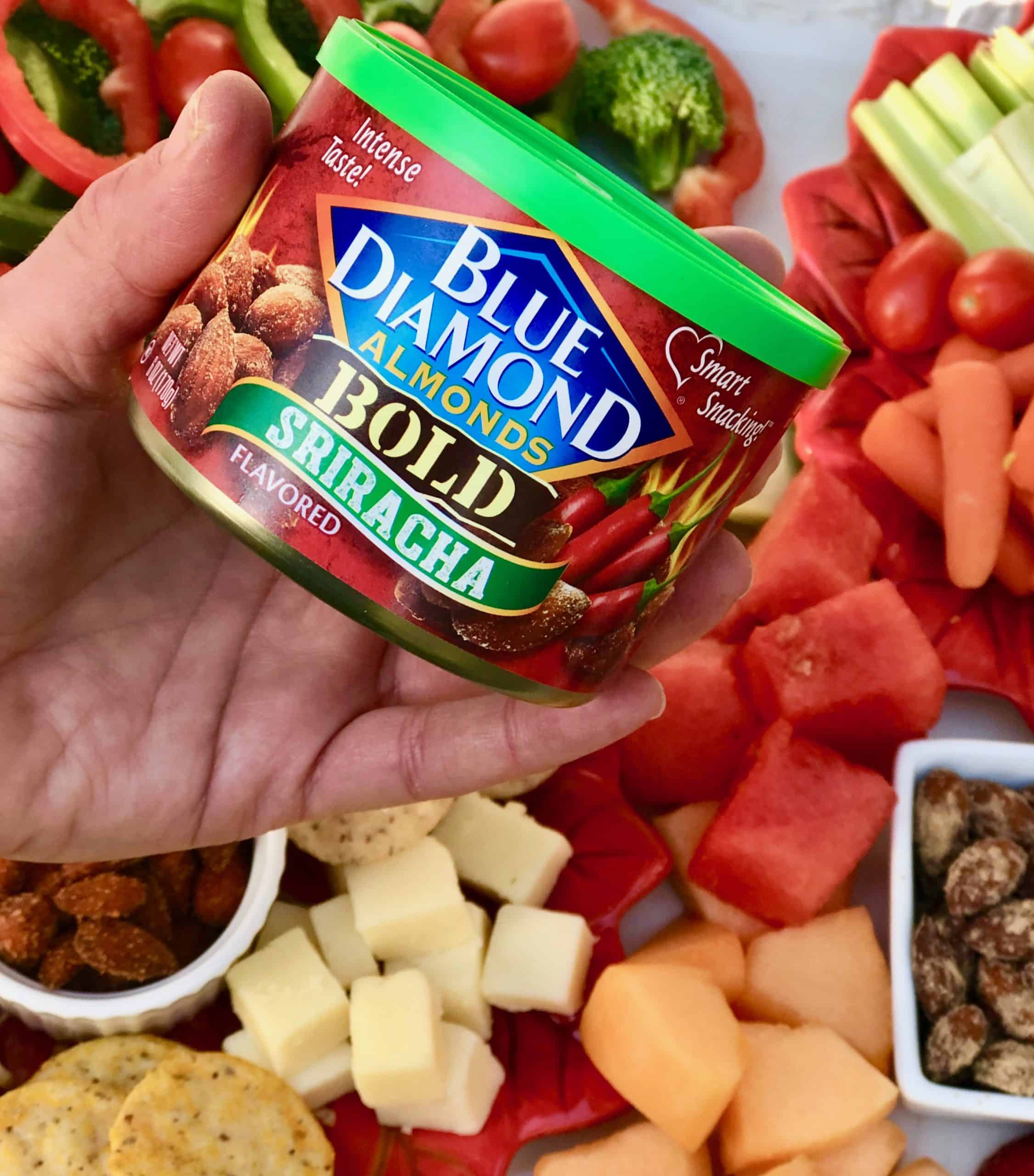 Can of Blue Diamond Sriracha Almonds with holiday platter in background.