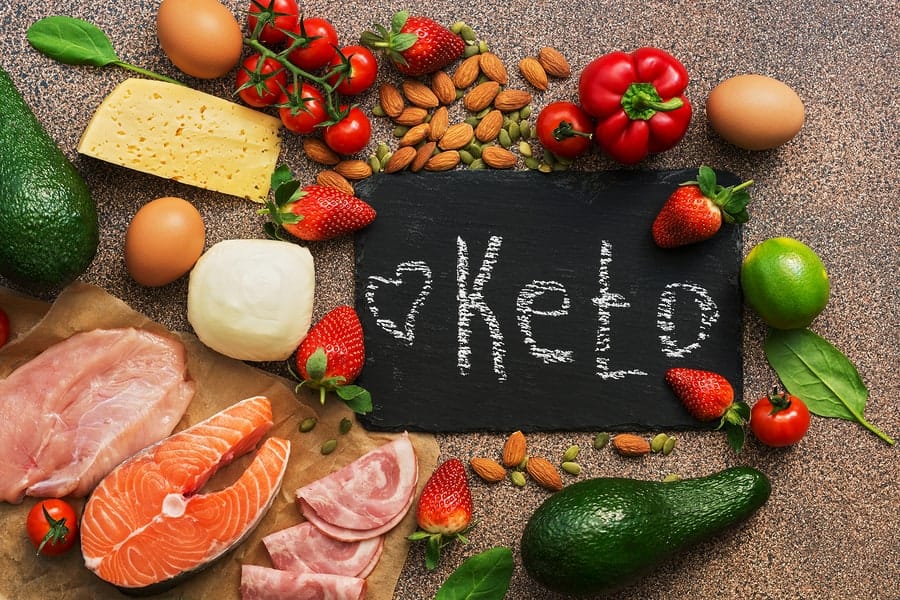 Keto diet food. Healthy low carbs products.Keto diet concept. Vegetables, fish, meat, nuts, seeds, strawberries, cheese on a brown background. Top view. Signboard