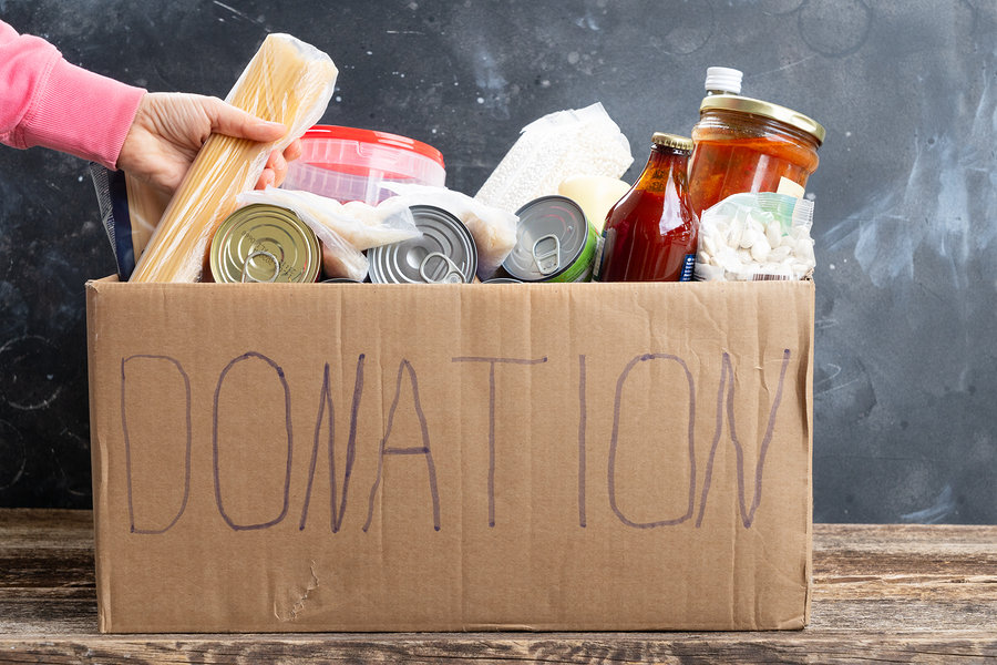 Woman putting food into Donate Box, donation and charity concept
