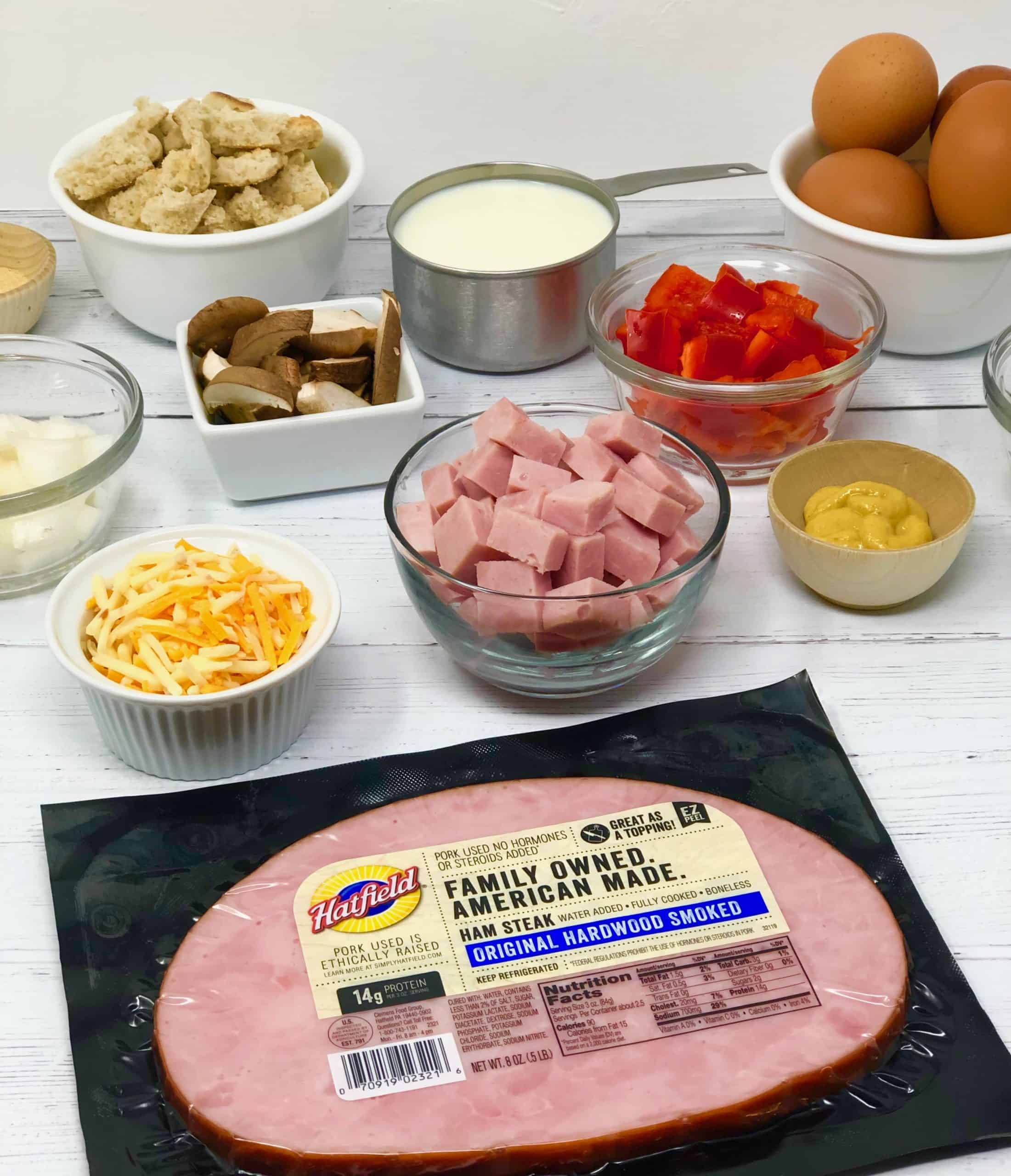 Hatfield Ham and Veggie Strata ingredients on a white wood background.