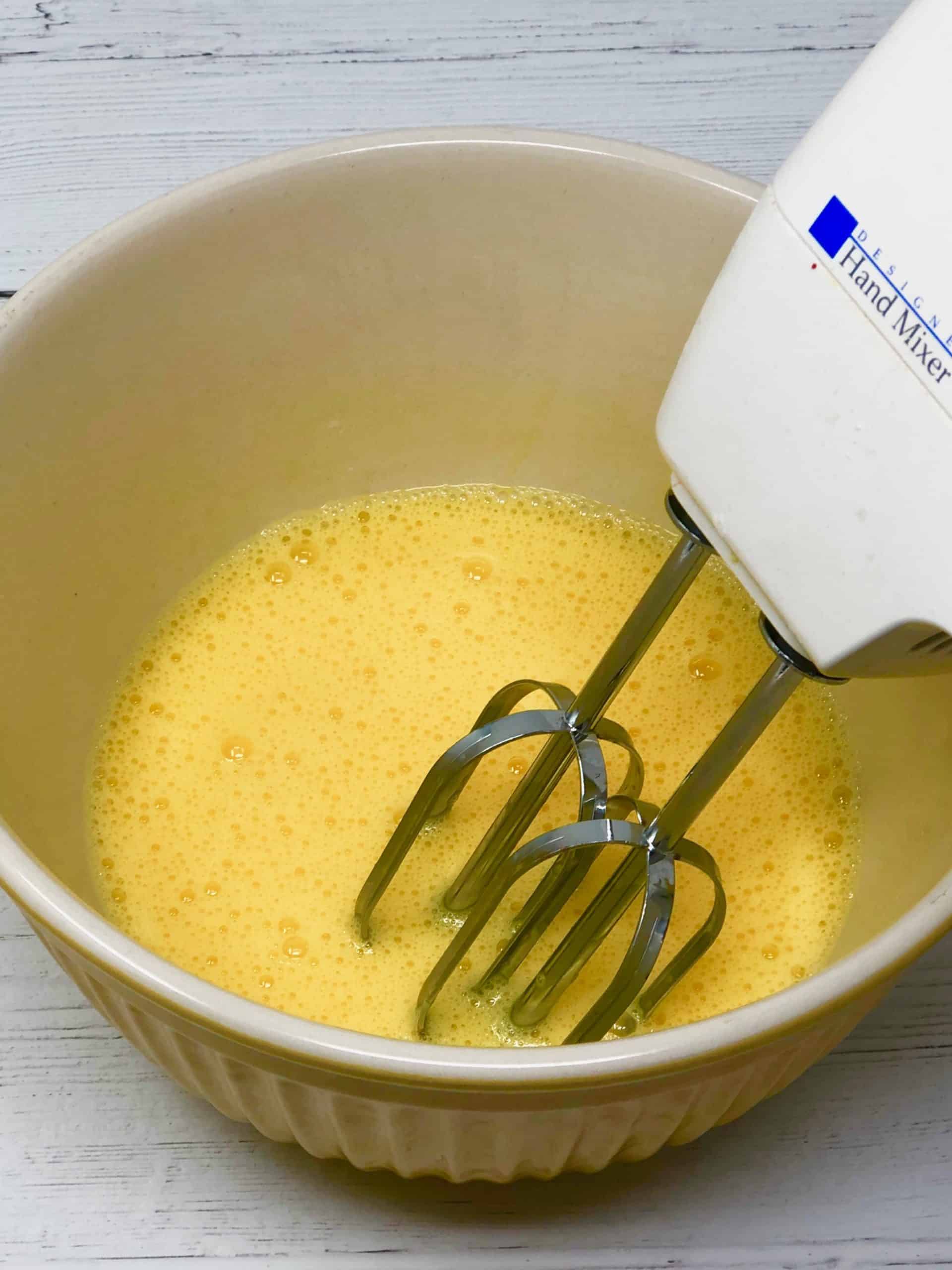 Eggs being blended with hand mixer.