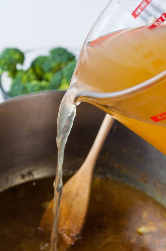 Vegetable stock being poured into a pot.