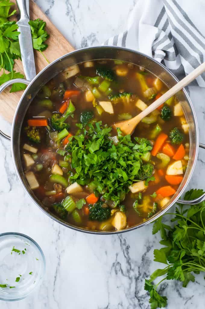 broccoli, carrots, celery, and parsnip in a pot with vegetable stock.