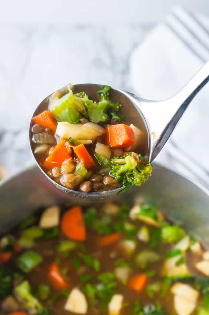 Vegan lentil soup on a serving ladle.