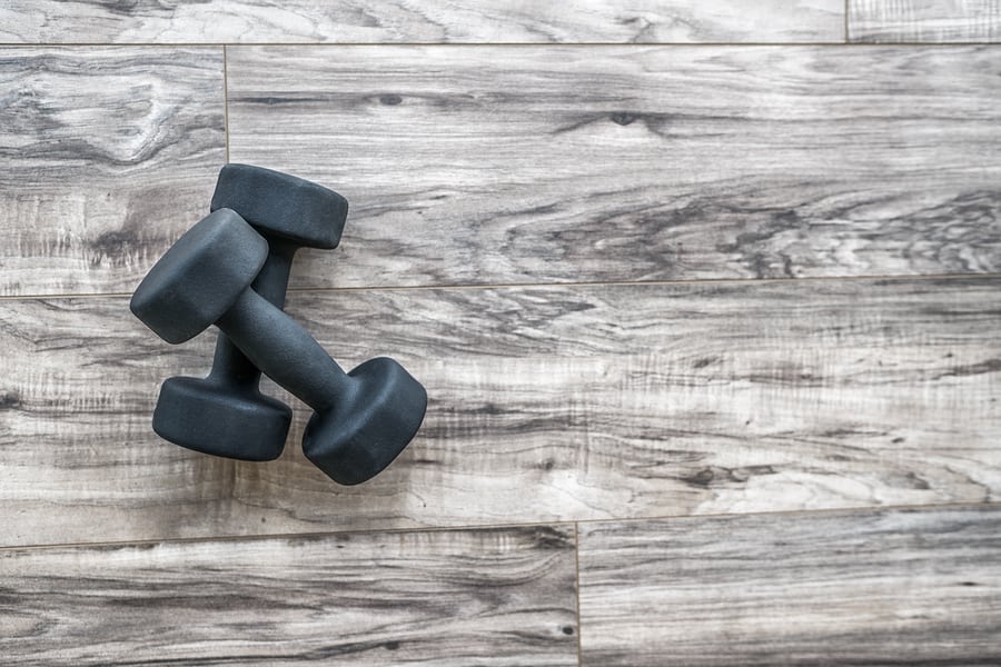 Training at home fitness concept: dumbbell weights on wood floor at fitness gym . Weight loss and health. Sport fit lifestyle.