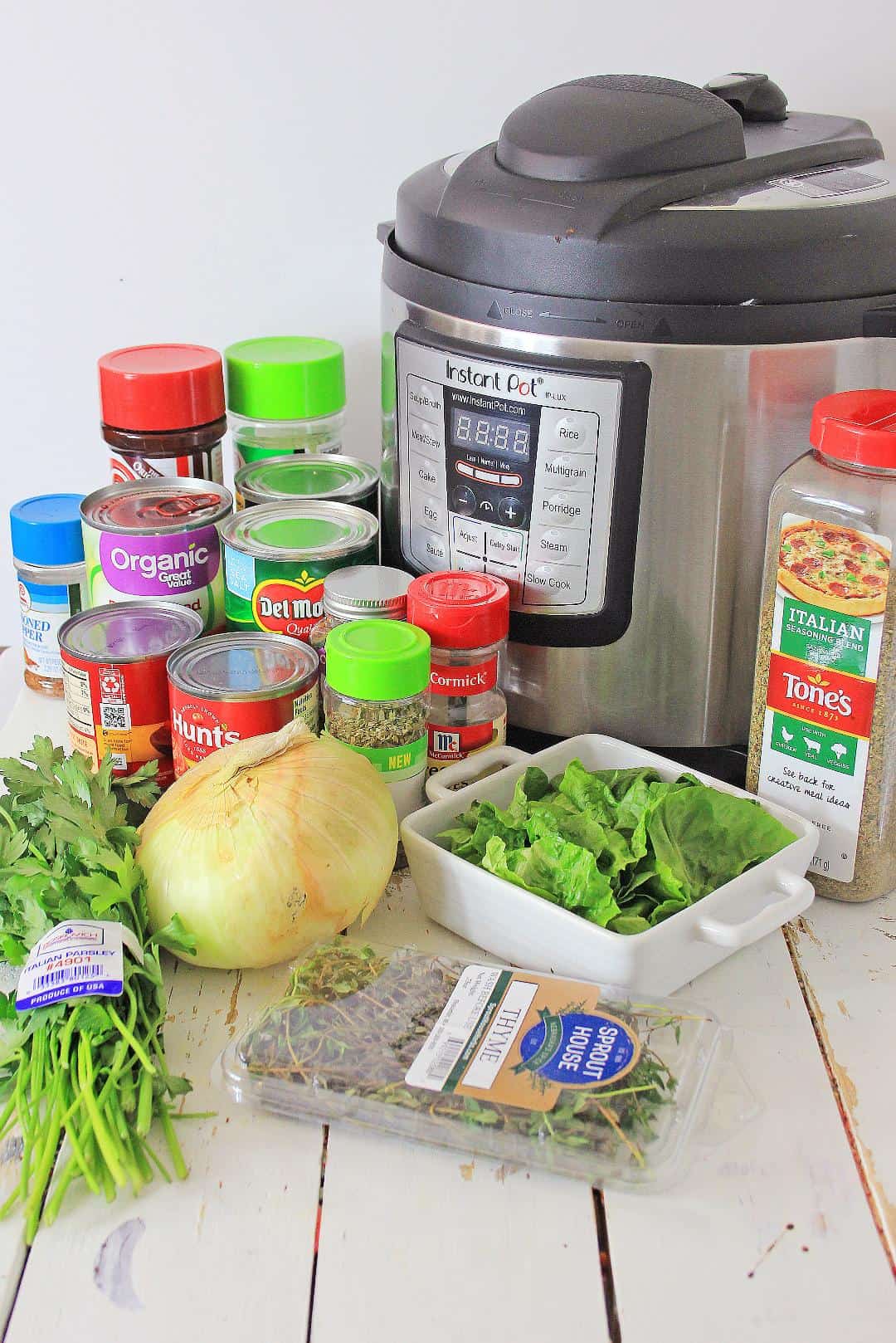 Instant Pot and ingredients for tomato soup on white background.