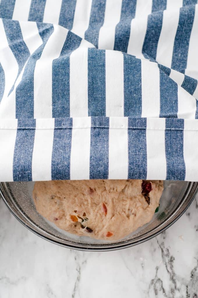 Hot Cross Bun Dough covered with a blue and white striped towel.