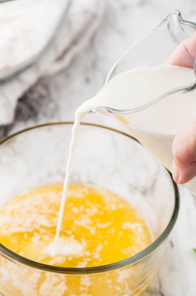 Milk being poured into glass bowl with butter.