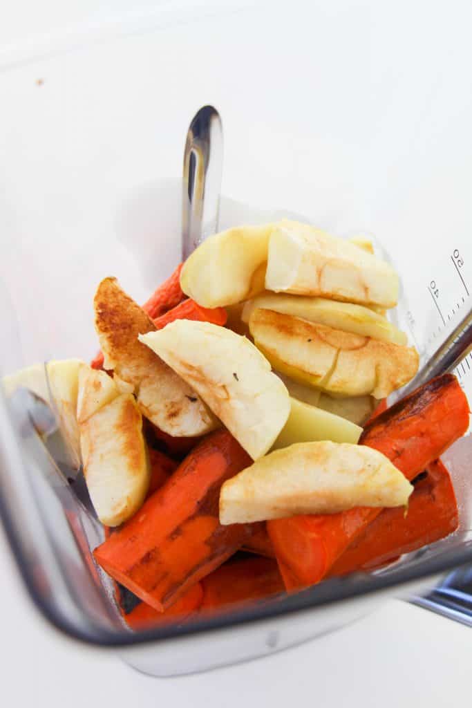 Roasted carrots and apples in a blender.
