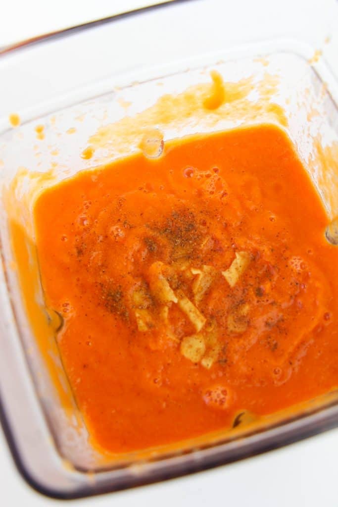 Pureed apples and carrots with nutmeg on top in a blender.