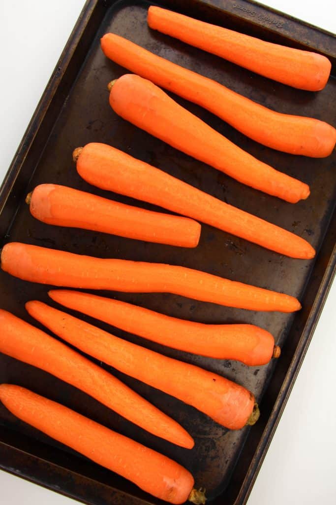 Whole carrots on a cookie sheet.