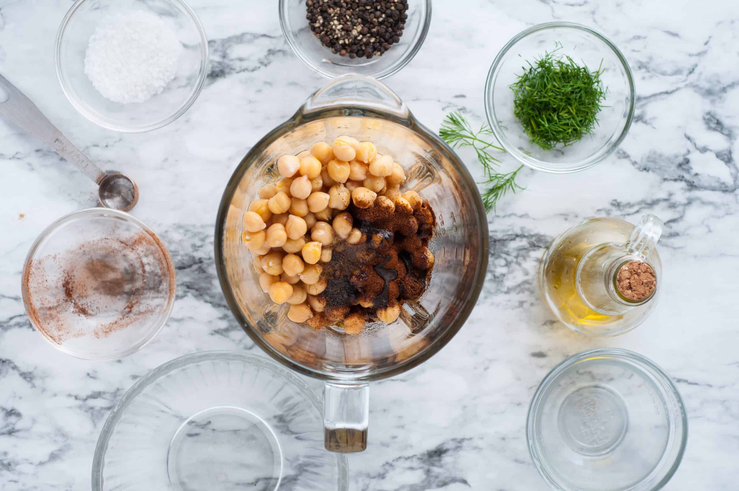 chickpeas with spices in a blender on a marble background