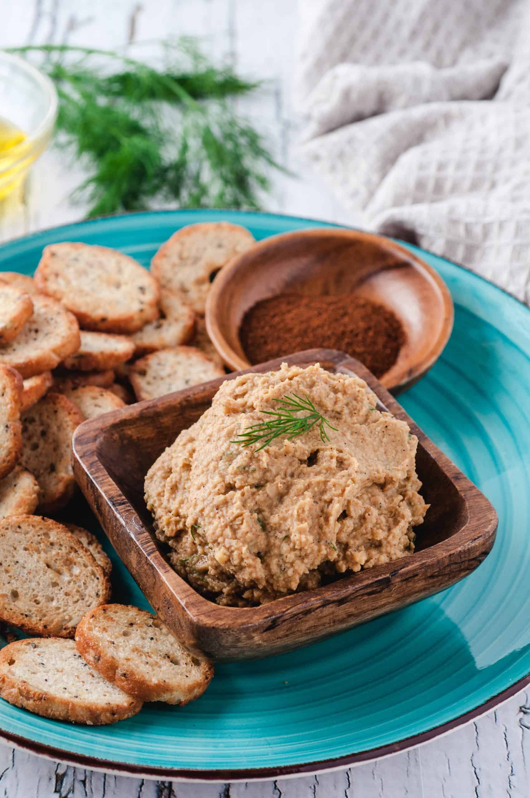 hummus and baguette chips served on a blue plate