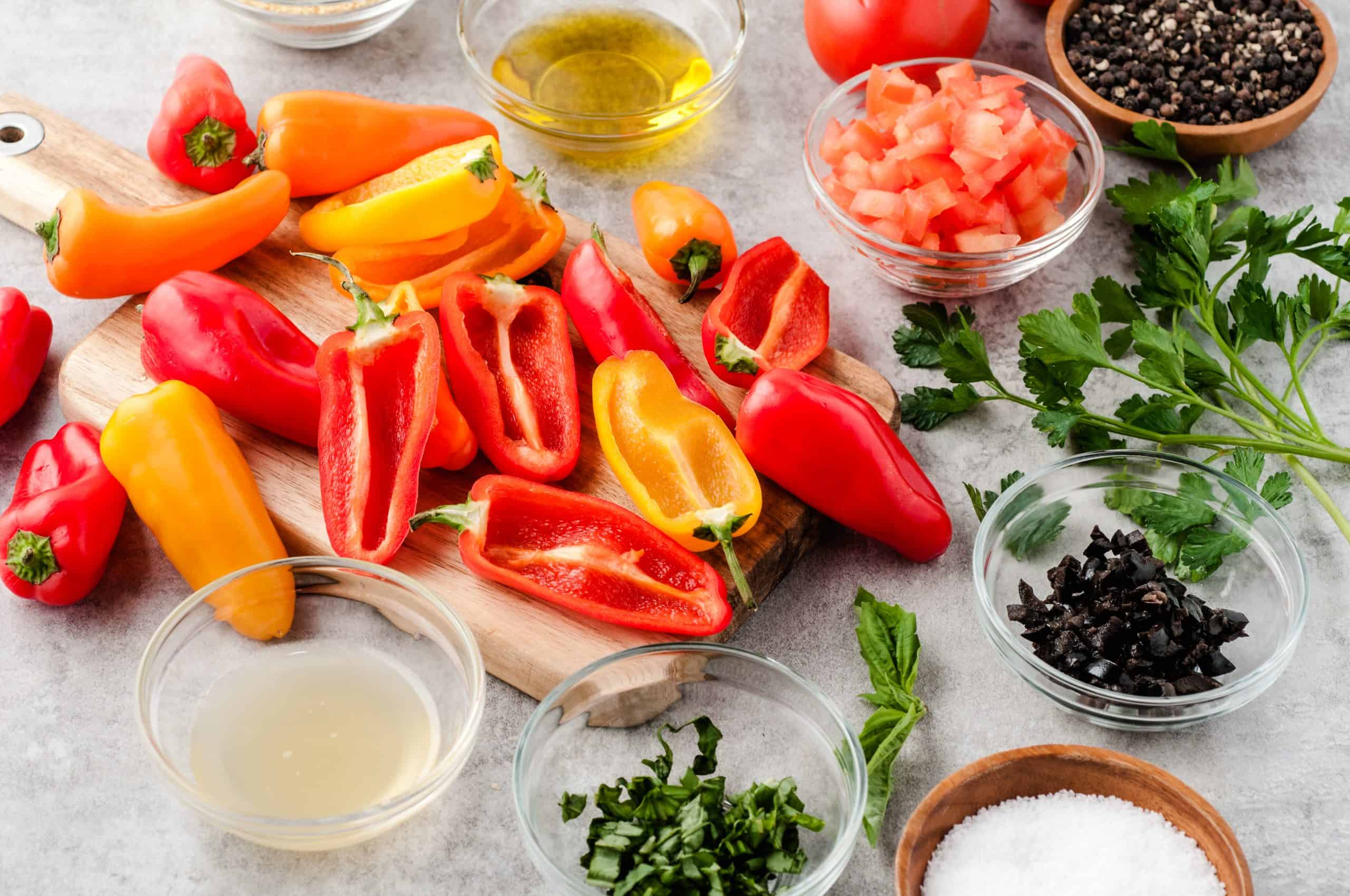 Mini peppers, olive oil, and herbs and spices on a counter top
