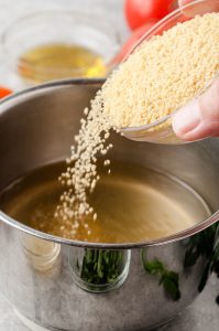 Couscous being poured into pot