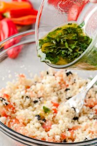 Dressing being poured over couscous