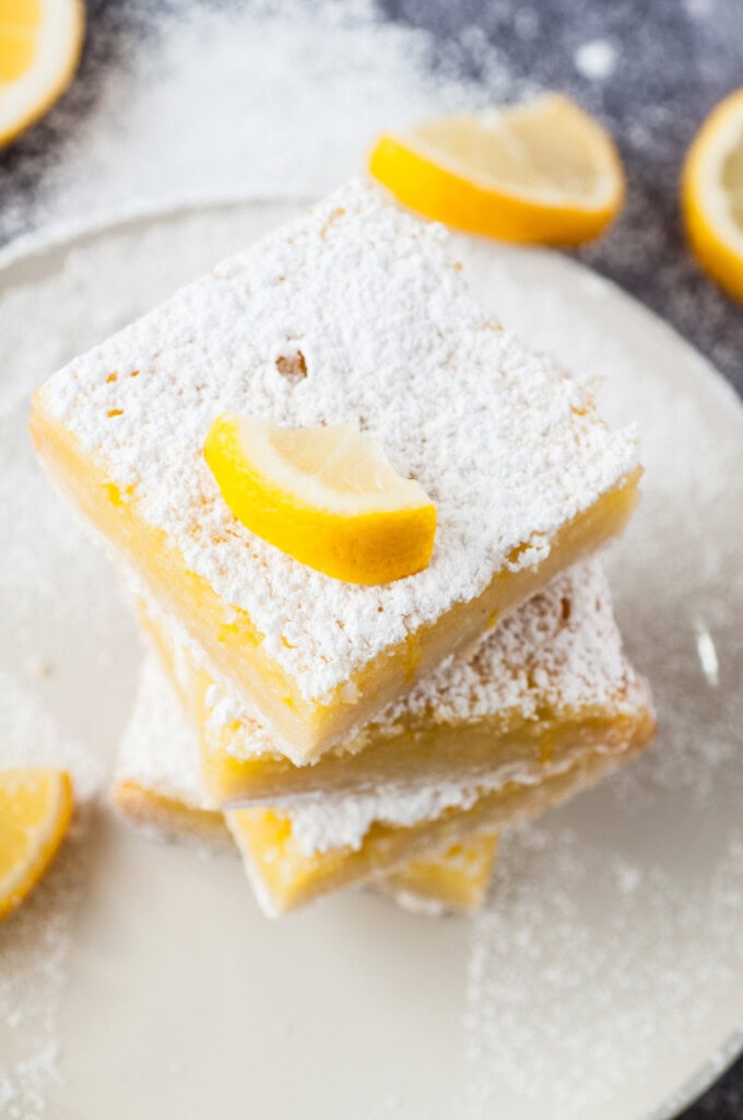 Homemade Lemon Bars with a slice of lemon on top.