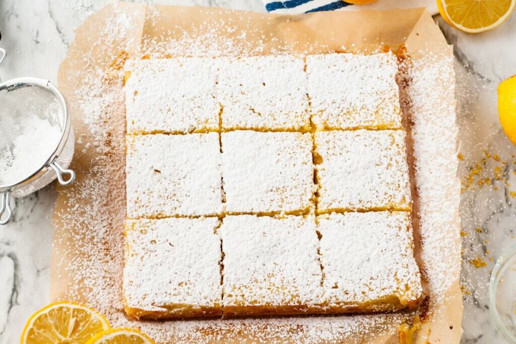 Overhead view of lemon bars sprinkled heavily with powdered sugar.