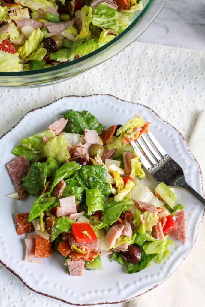 Overhead view of chopped Italian salad on a white plate with a fork.