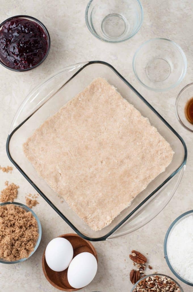 Coconut Raspberry Bar crust pressed in baking dish.