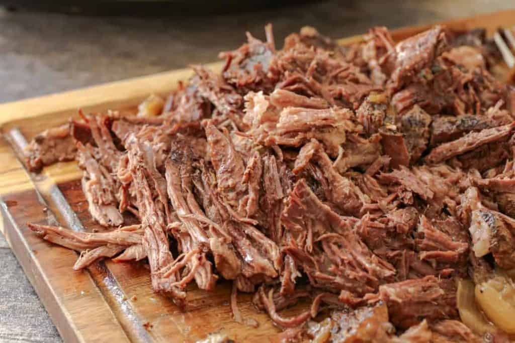 Shredded beef on a cutting board.