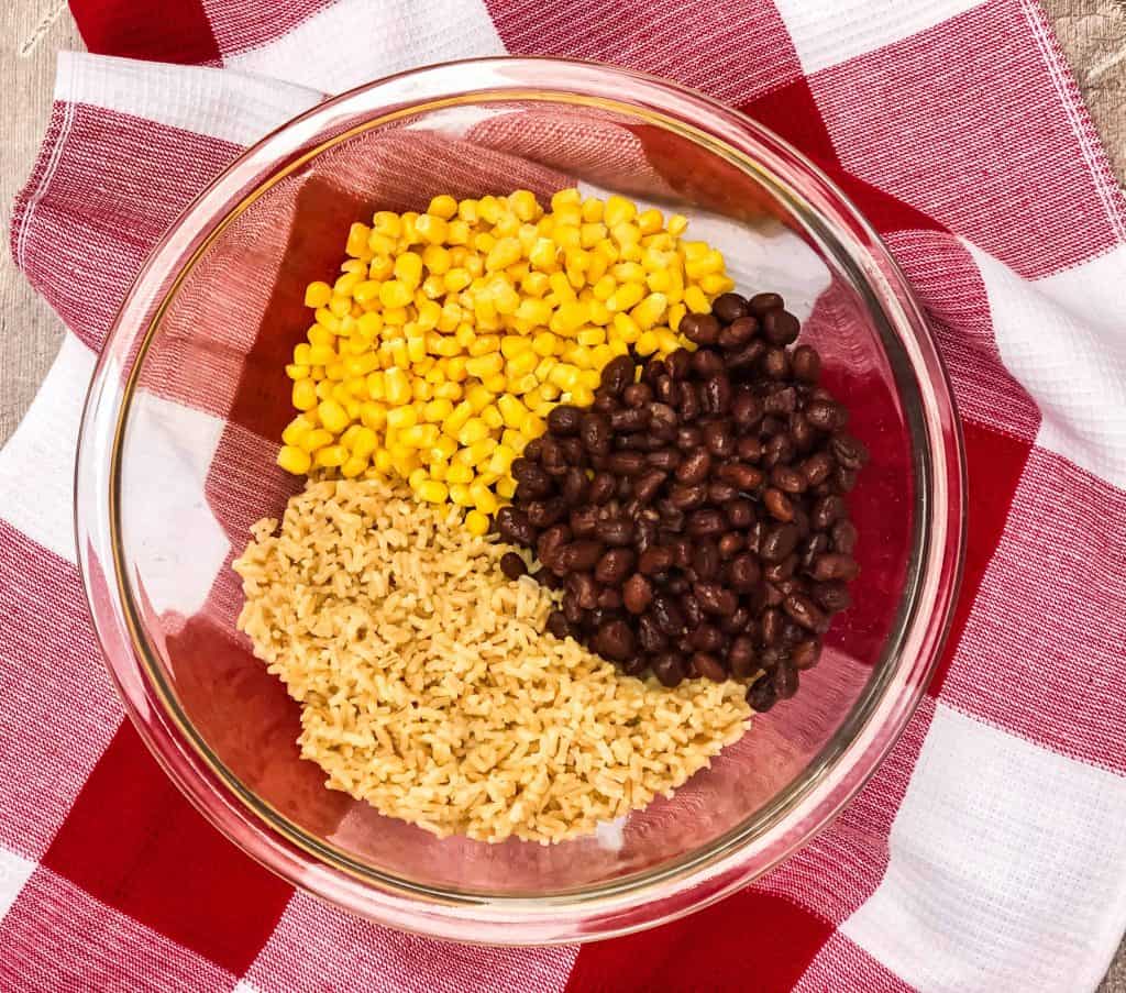 Corn, black beans and brown rice in a glass bowl.