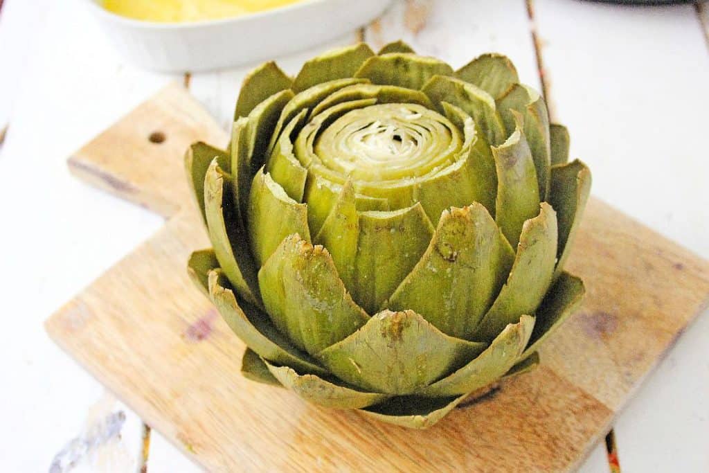Cooked Instant Pot Artichoke on a cutting board.