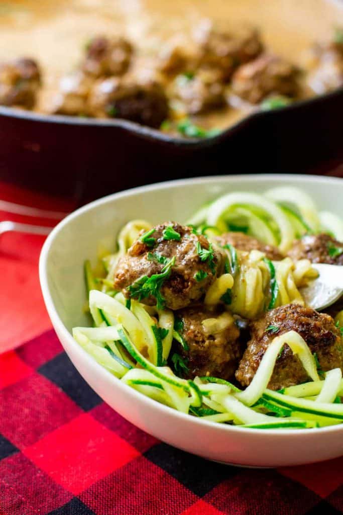 Keto Swedish Meatballs in a white bowl and a black iron skillet.