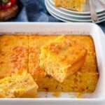 Easy Mexican Cornbread in a white ceramic baking dish with 2 pieces cut out.