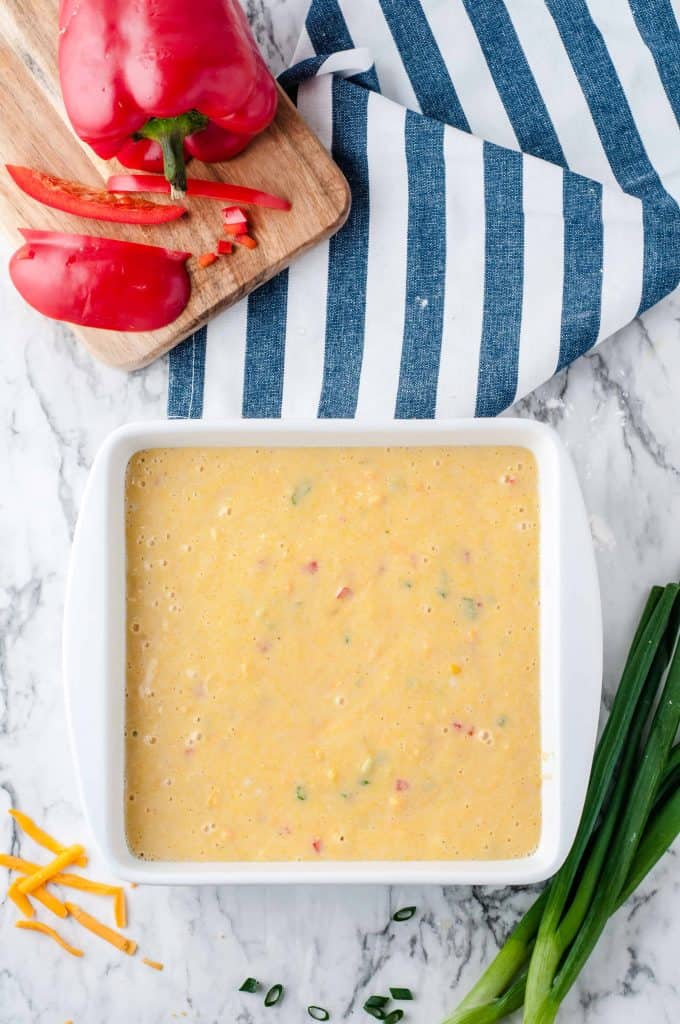 Mexican cornbread batter in an 8x8 dish ready for the oven.