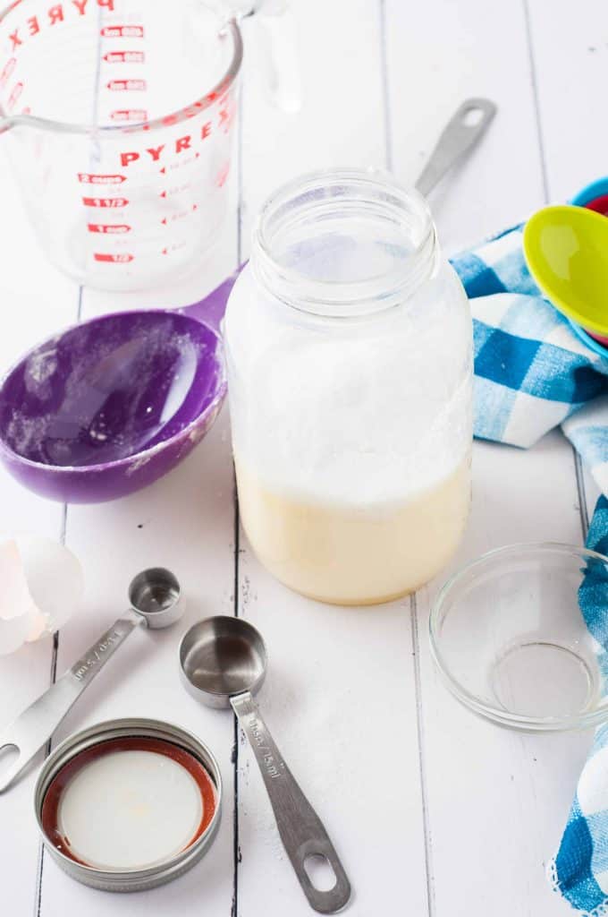 Pancake mix in a jar with measuring cups and spoons beside it.