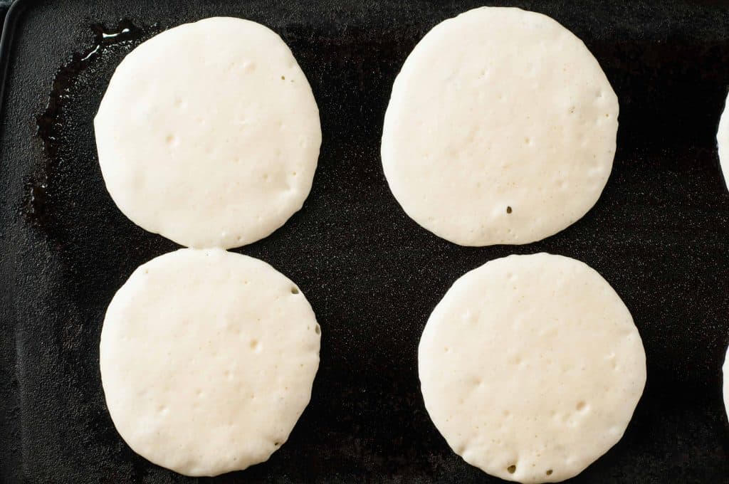 4 pancakes on a griddle.